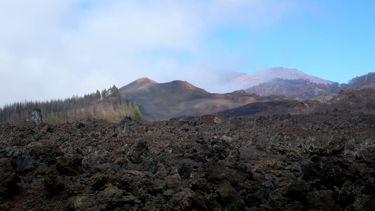 Volcán Chinyero con sus campos de lava; protagonizó en 1909 la última erupción de Tenerife. Al fondo, Teide y Pico Viejo.
